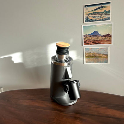 Grey DF54 Coffee Grinder with black metal dosing cup on wooden table - Grind Logic
