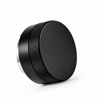 Angled top view of the black Grind Logic coffee distributor, showing its smooth top and textured grip